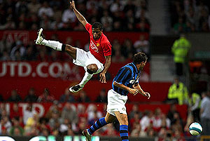 Manchester United's Patrice Evra jumps for the ball. AP Photo/Jon Super