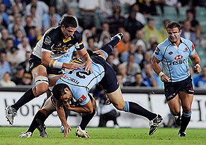 Sam Harris (centre) of the NSW Waratahs is tackled by the ACT Brumbies George Smith (centre) and Mitchell Chapman (left) during their round 4 Super 14 match in Sydney. AAP Image/Paul Miller.
