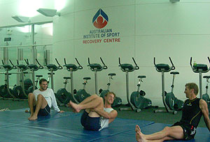 Tom Laurich, Jeremy Stevenson and James Tomkins cool down stretching on the matts after training, prior to the water treatment.  - photo courtesy of James Chapman