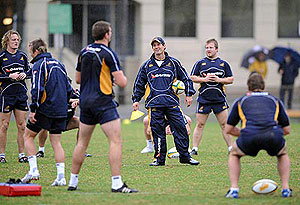 New Wallabies coach Robbie Deans watches his players warm up during the Wallabies first training session at Manly Oval, Sydney, June 3, 2008. AAP Image/Dean Lewins