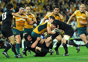 Australian Adam Ashleigh Cooper (centre) is tackled by New Zealand's Jimmy Cowan (right) and Ali Williams (left). AAP Image/Dave Hunt