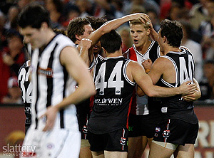 Nick Riewoldt of St Kilda is mobbed by team-mates while Martin Clarke of Collingwood looks on during the AFL 1st Semi Final between the St Kilda Saints and the Collingwood Magpies at the MCG. Slattery Media Group