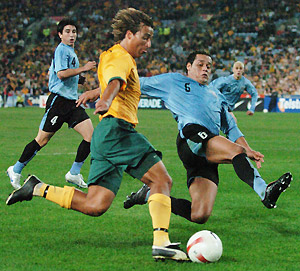 Uruguay's Dario Rodriguez tackles Australia's Nick Carle during the Australia versus Uruguay soccer match at Telstra Stadium, Sydney, Saturday, June 2, 2007. Uruguay defeated Australia 2 - 1. AAP Image/Dean Lewins