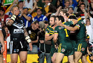 Australian players (right) celebrate Greg Inglis' try as the New Zealand look on in their pool match of the Rugby League World Cup in Sydney on Sunday, Oct. 26, 2008. (AAP Image/Paul Miller)