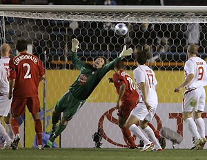 Goalkeeper Richard Gillespie, in green, of New Zealand's Waitakere United tries to save a goal scored by Daniel Mullen, unseen, of Australia's Adelaide United FC during their opening match at the FIFA Club World Cup soccer tournament in Tokyo Thursday, Dec. 11, 2008. Adelaide United FC won the match, 2-1. AP Photo/Shuji Kajiyama