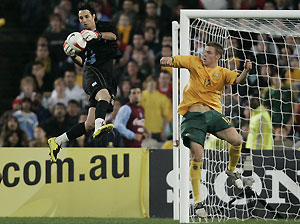 Uruguay goalkeeper Fabian Carini, second from left, is airborne as he takes the ball away from Australia's Danny Allsopp during their soccer international in Sydney, Saturday, June 2, 2007. Uruguay won 2-1. AP Photo/Mark Baker