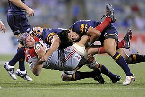 Crusaders' Thomas Waldrom is hammered into the ground by Brumbies players in the Super 14 rugby match at Canberra Stadium, Saturday, Feb. 21, 2009. AAP Image/Alan Porritt