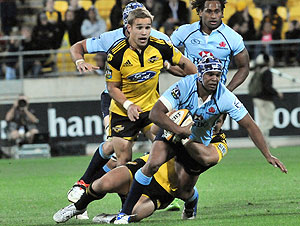 Waratahs Kurtley Beale is taken in a Hurricanes tackle in the Super 14 rugby match at Westpac Stadium, Wellington, New Zealand, Saturday, Feb. 14, 2009. (AAP Images/NZPA, Ross Setford)