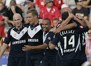Melbourne Victory's Archie Thompson (centre) and Daniel Allsopp (left) celebrate with team mates after Carlos Hernandez kicked their first goal during the A league 1st semi final match in Adelaide between Adelaide United and Melbourne Victory, Saturday, Feb. 7, 2009. AAP Image/Rob Hutchison