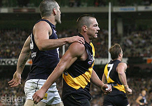 Brendan Fevola of Carlton comforts Ben Cousins of Richmond as Cousins hobbles from the field during the AFL Round 01 match between the Richmond Tigers and the Carlton Blues at the MCG.