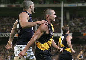 Brendan Fevola of Carlton comforts Ben Cousins of Richmond as Cousins hobbles from the field during the AFL Round 01 match between the Richmond Tigers and the Carlton Blues at the MCG.