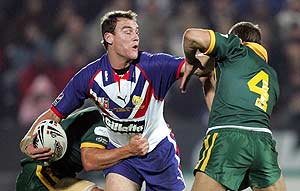 Great Britain's Gareth Ellis, center, releases the ball despite the attention of Australia's Matt Cooper during their Rugby League Tri-Nations match at The KC Stadium, Hull, England, Saturday, Nov. 19, 2005. AP Photo/Paul Ellis