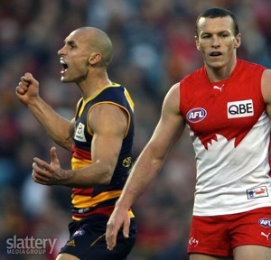 Tyson Edwards of the Crows celebrates a goal as Jared Crouch of the Swans looks on during the AFL Round 13 match between the Adelaide Crows and the Sydney Swans at AAMI Stadium.
