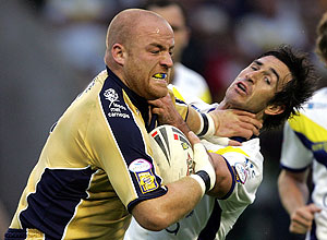 Australian Rugby League player Andrew Johns, right, is handed off by Leeds Rhinos' Danny Ward. AP Photo/Paul Ellis