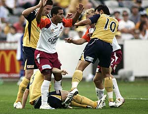 Queensland Roar's Tahj Minniecon (second from left) fights for a ball against Central Coast Mariners during their A-League match in Gosford, Saturday, Jan. 10, 2009. Queensland Roar won 4-3. AAP Image/Aman Sharma