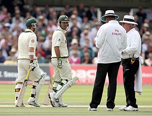 After a short delay Australia's Phillip Hughes, left, walks back to the pavilion as Ricky Ponting, 2nd left, looks at umpires Billy Doctrove, 2nd right, and Rudi Koertzen on the fourth day of the second Ashes Test match between England and Australia at Lord's cricket ground in London, Sunday, July 19, 2009. Hughes was caught out by Andrew Strauss off a ball from James Anderson for 17 runs. AP Photo/Tom Hevezi
