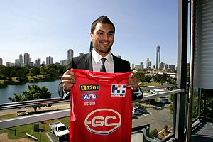 Brisbane Broncos rugby league player Karmichael Hunt poses with a Gold Coast AFL franchise jersey following a press conference on the Gold Coast, Tuesday, July 28, 2009, to announce his three year contract with new AFL franchise Gold Coast Football Club. Hunt will commence his AFL playing career in May 2010 . AAP Image/Patrick Hamilton