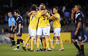 Melbourne Victory's Archie Thompson (right) walks past as the Central Coast Mariners players celebrate winning round 1 of the 2009/10 A-League season in Melbourne, Thursday, Aug. 6, 2009. The Mariners beat Victory 2-0. AAP Image/Joe Castro