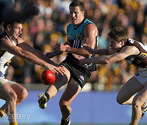 Brent Guerra and Liam Shiels of the Hawks attempt to smother the kick of Nick Salter of Port during the AFL Round 18 match between Port Adelaide Power and the Hawthorn Hawks at AAMI Stadium. The Slattery Media Group