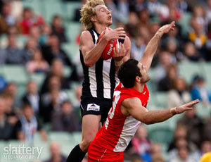 Collingwood's Dale Thomas marks over Sydney's Heath Grundy during the AFL Round 21 match between the Collingwood Magpies and the Sydney Swans at the MCG. Slattery Images