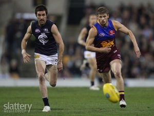 Kade Simpson and Justin Sherman chase the ball during the AFL 2nd Elimination Final between the Brisbane Lions and the Carlton Blues at the Gabba.