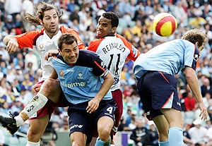 Sydney FC'S Mark Rudan (centre) competes for the ball with Saso Ognenovski (left) and Reinaldo da Costa of the Queensland Roar during their A-League clash at Aussie Stadium, Sydney, Sunday, Oct. 8, 2006. The match ended in a 1-1 draw. AAP Image/Jenny Evans