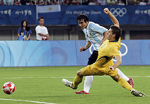 Argentina's Ezequiel Lavezzi, left, scores the winning goal as Australia's Matthew Spiranovic (5) defends. AP Photo/Eugene Hoshiko