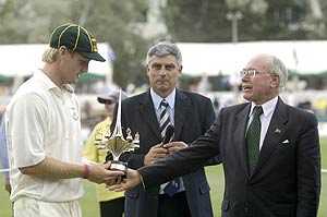 Prime Minister John Howard presents the trophy to his team captain Cameron White. AAP Image/Alan Porritt