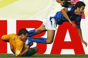 Australia's Lucas Neill, bottom, trips Italy's Fabio Grosso in the penalty box. AP Photo/Kevork Djansezian