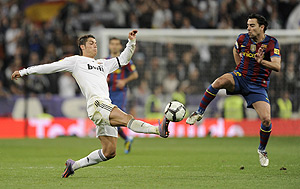 Real Madrid's Cristiano Ronaldo from Portugal, left, duels for the ball with Barcelona's Xavi Hernandez. AP Photo/Daniel Ochoa de Olza
