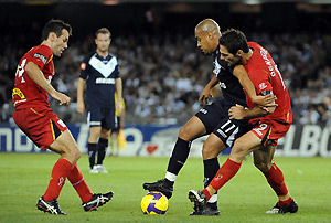 Melbourne Victory's Ney Fabiano is challenged by Adelaide United's Sasa Ognenovski and Paul Reid. AAP Image/Joe Castro