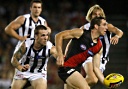 Dane Swan moves to tackle an Essendon player
