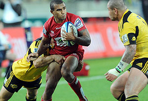 Will Genia of the Reds tries to break a Hurricanes tackle