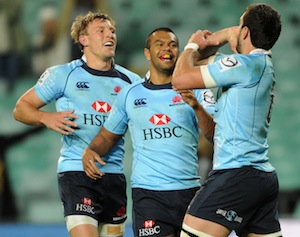The Waratahs Dave Dennis celebrates his try with teammates Kurtley Beale and Lachie Turner