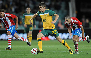 Australia's Dario Vidosic (centre) takes the ball up field despite pressure from Paraguay's Dario Veron. AAP Image/Dean Lewins