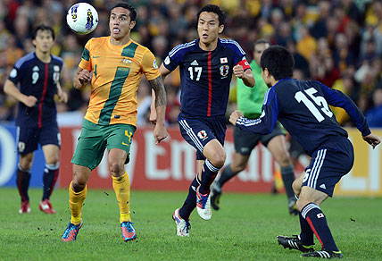 Socceroos player Tim Cahill competes for the ball with Japan's Makoto Hasebe. AAP Image/Dave Hunt