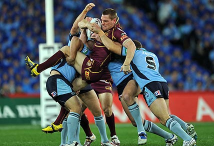 Queensland's Brent Tate (centre) is tackled by Greg Bird (left), Mitchell Pearce and Robbie Farrah (right) of New South Wales during game 2 of the State of Origin Rugby League series in Sydney on Wednesday, June 13, 2012. (AAP Image/Paul Miller