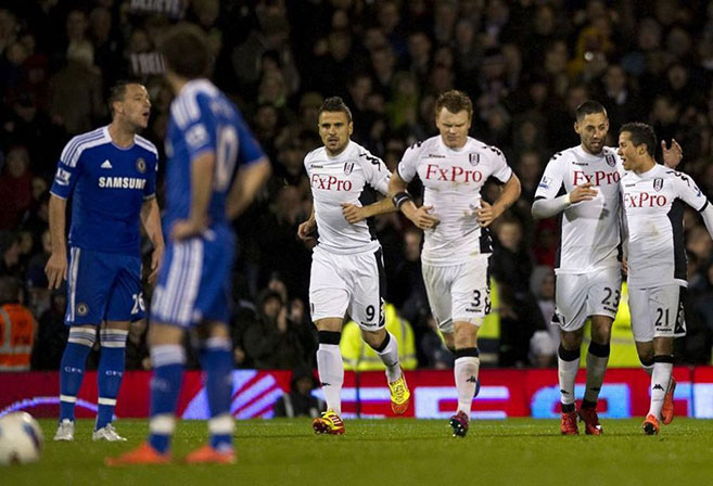 Fulham players celebrate a goal as Chelsea's John Terry looks on.