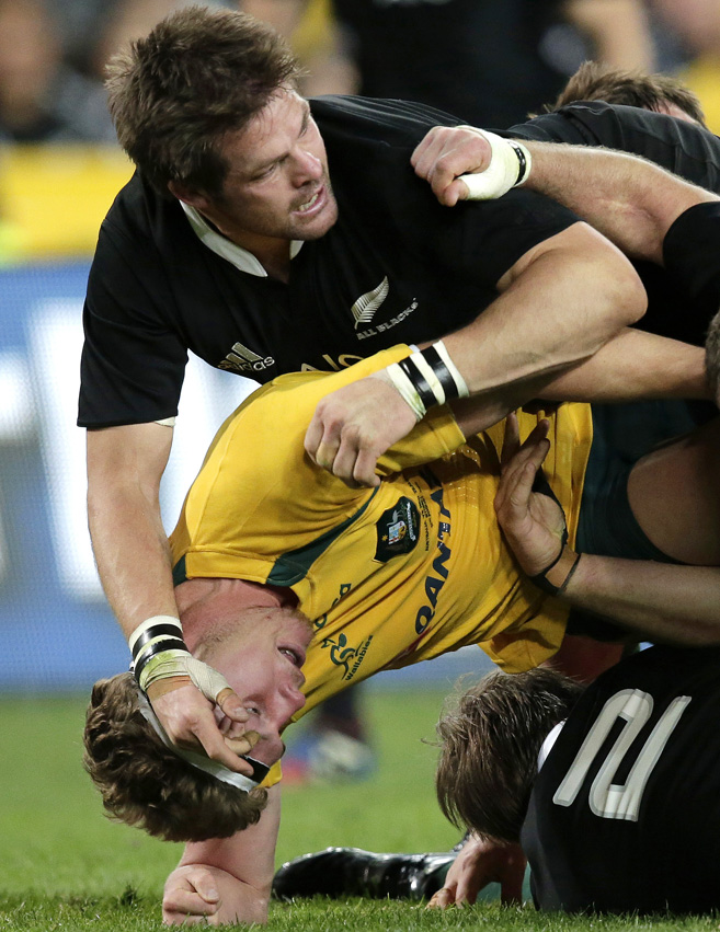 New Zealand's Richie McCaw, top, gets the upper hand on his Australian open side counterpart Michael Hooper