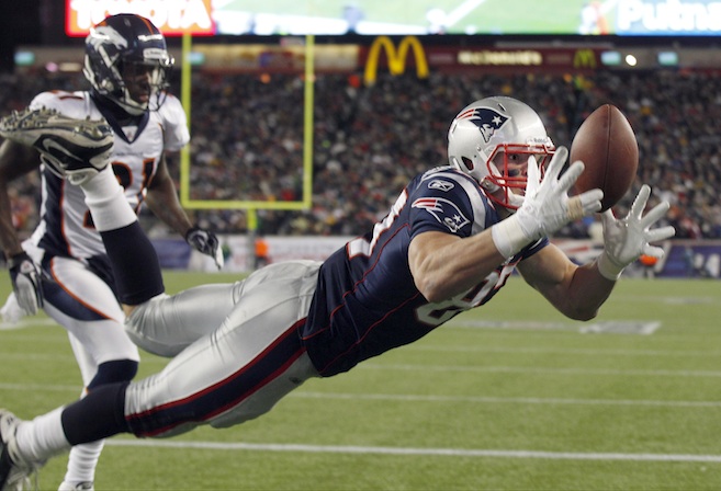 New England Patriots tight end Rob Gronkowski (87) catches a 10-yard touchdown pass while being defended by Denver Broncos cornerback Andre' Goodman (21) during the first half of an NFL divisional playoff football game Saturday, Jan. 14, 2012, in Foxborough, Mass. (AP Photo/Charles Krupa)