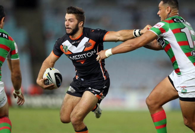 James Tedesco of the Wests Tigers fends off souths rabbitohs player