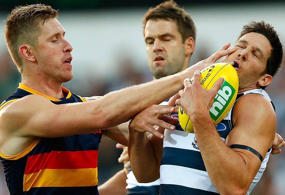 Harry Taylor of the Cats is poked in the eye by Shaun McKernan of the Crows