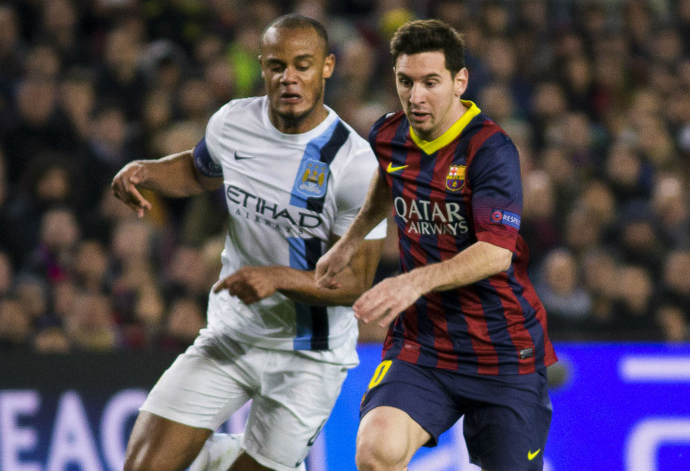 Vincent Kompany and Lionel Messi compete for the ball