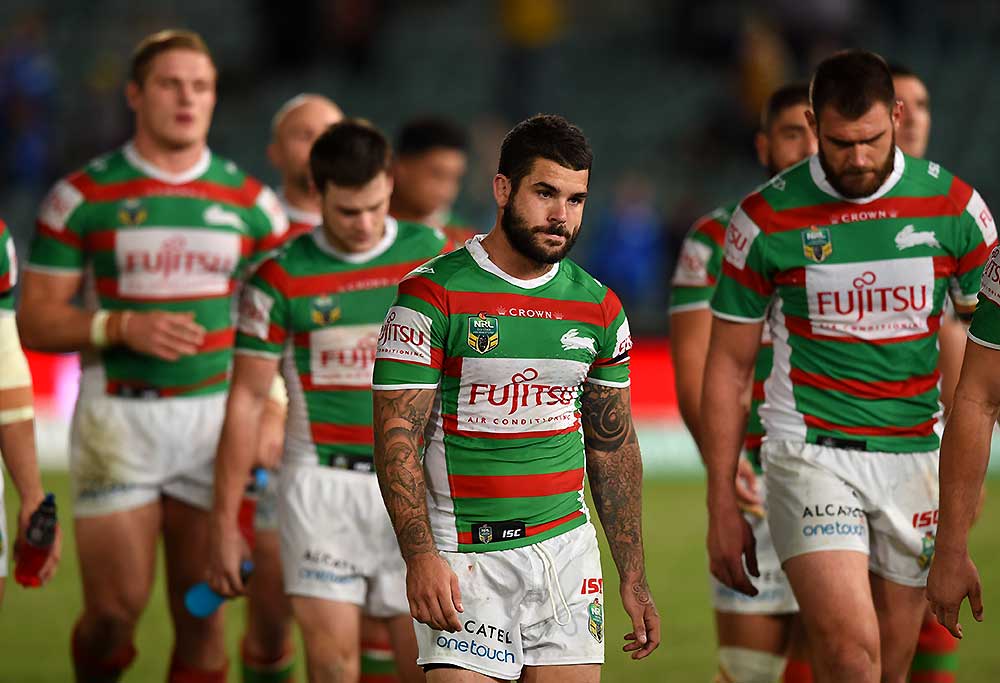 Adam Reynolds (centre) of the Rabbitohs leads the team off the field