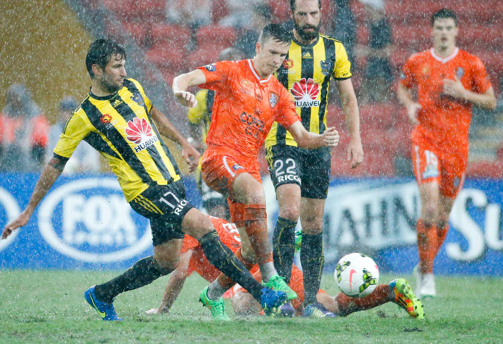 Roar midfielder Matt McKay (centre) in the rain