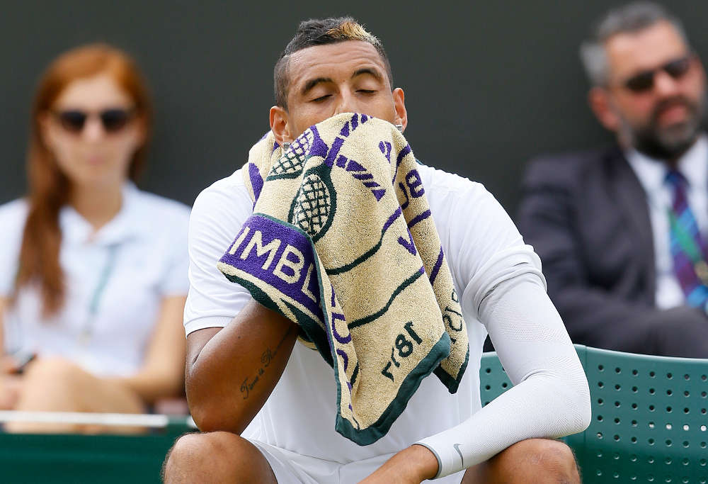 Nick Kyrgios of Australia wipes his face with a towel