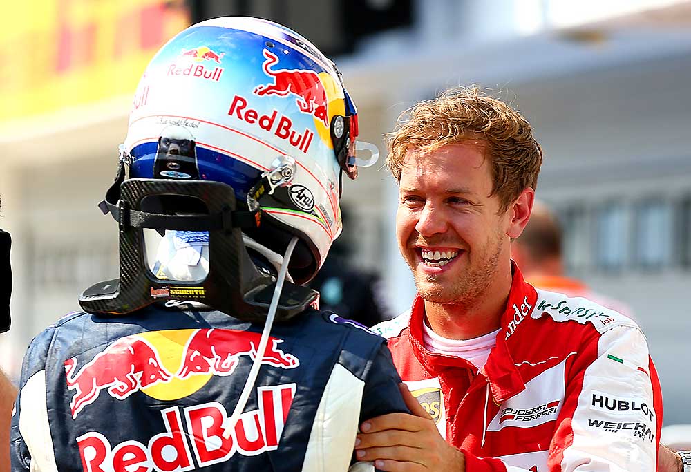 Sebastian Vettel of Germany and Ferrari speaks with Daniel Ricciardo of Australia and Infiniti Red Bull Racing