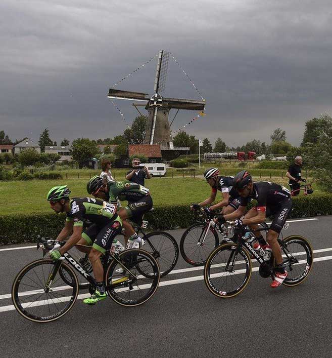 Cycling past windmill in the Netherlands
