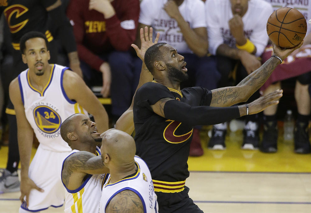 Cleveland Cavaliers forward LeBron James, right, shoots against the Golden State Warriors