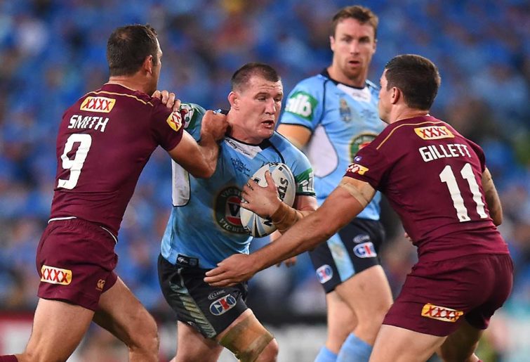Paul Gallen of the Blues is tackled by Cameron Smith and Matthew Gillett of the Maroons
